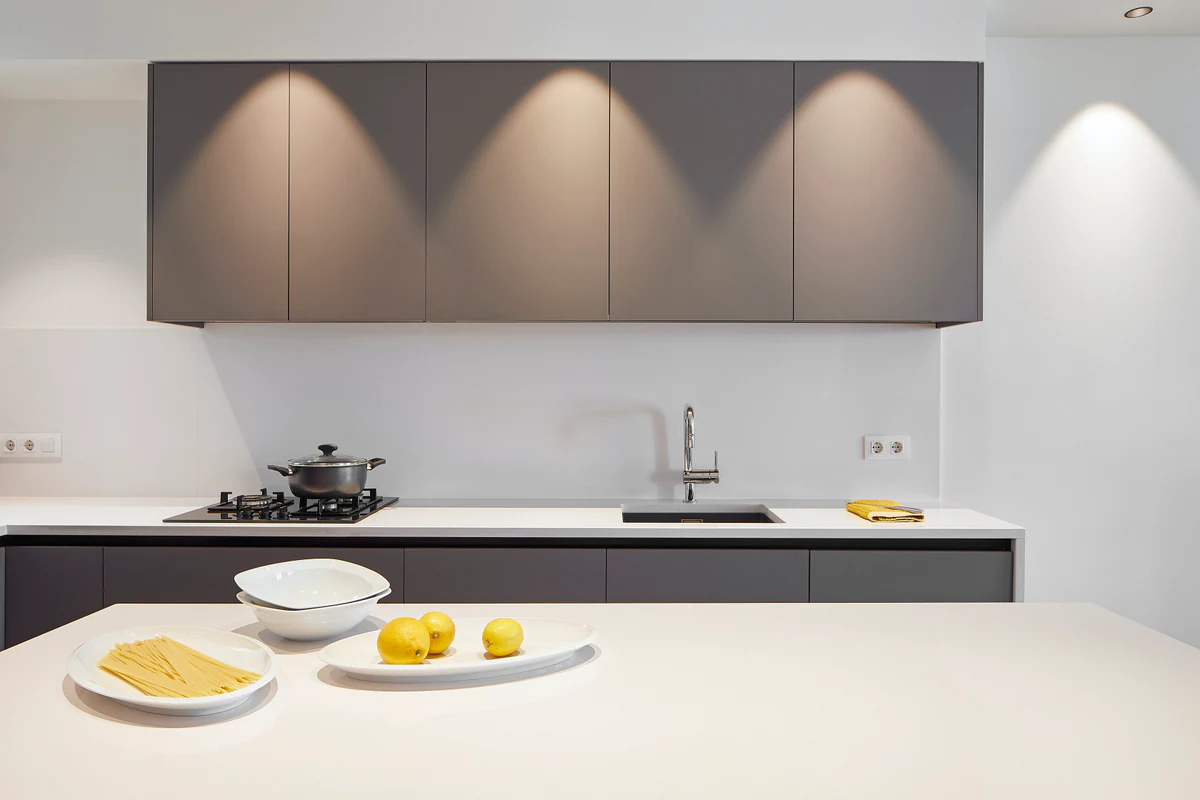 Kitchen with spotlights casting light onto the wall cabinets