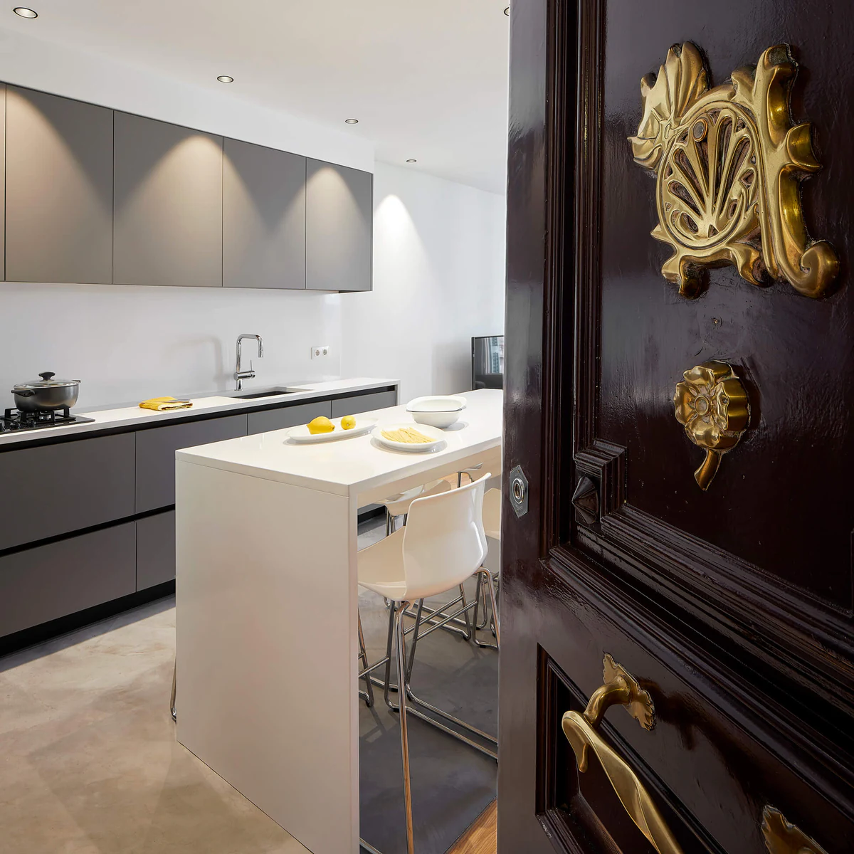 View of an illuminated kitchen next to a carved wooden door