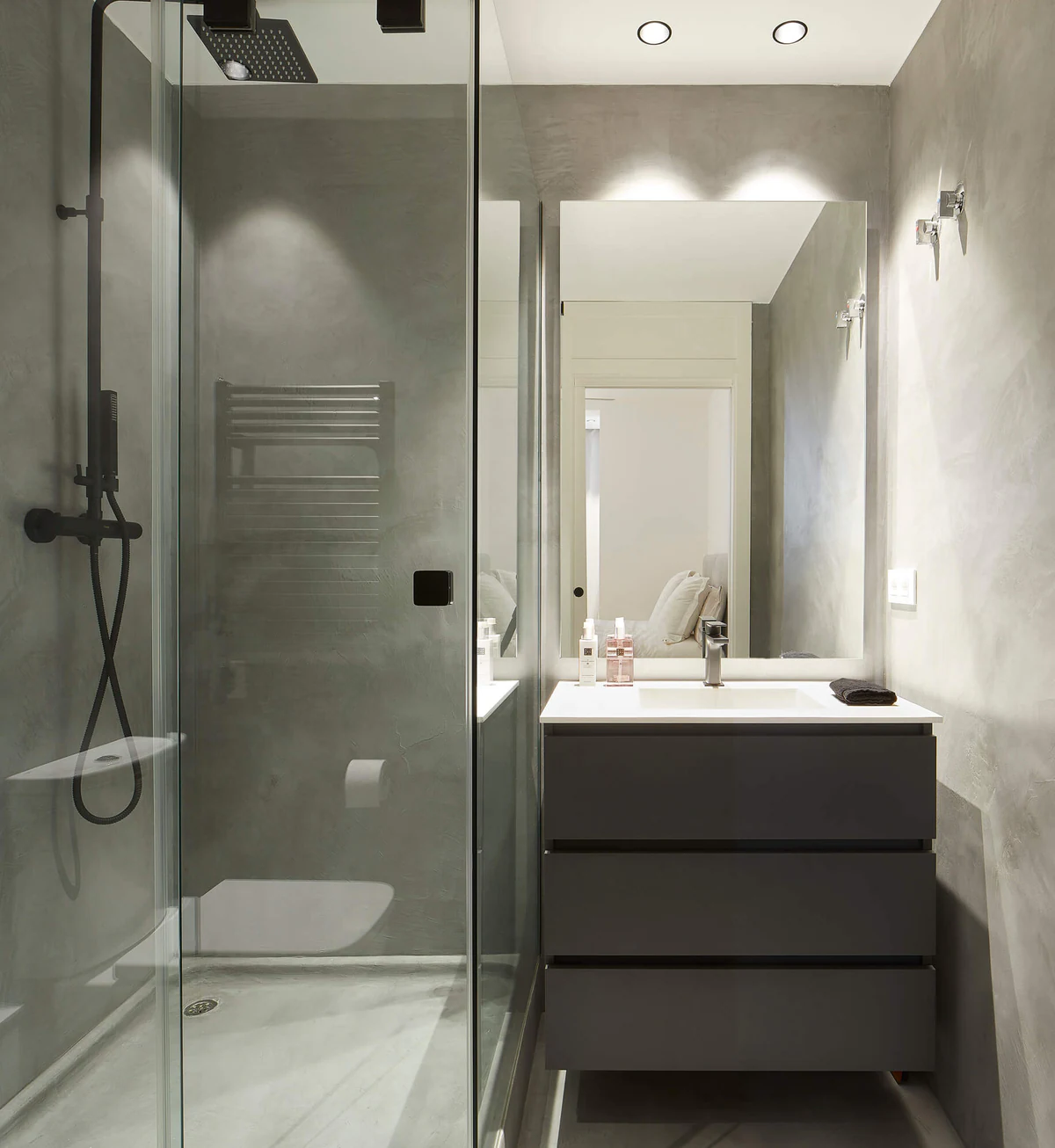 Grey bathroom with a glass shower and illuminated mirror