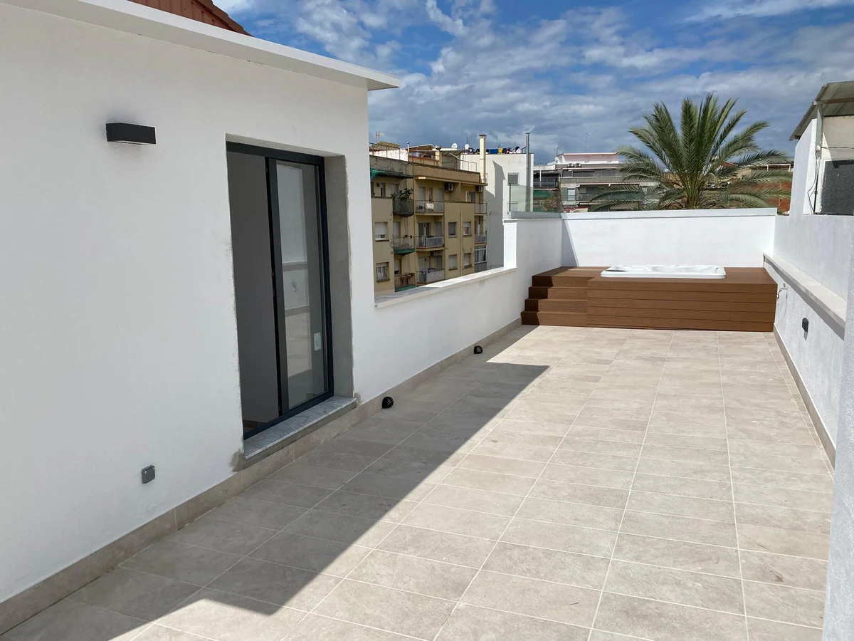 Rooftop terrace with wall lights and light-coloured paving
