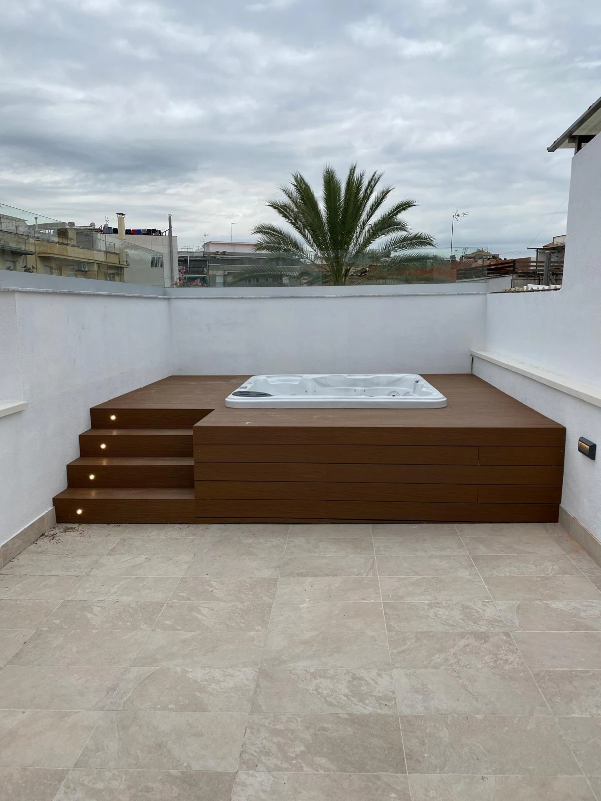 Raised jacuzzi on a terrace with wooden steps