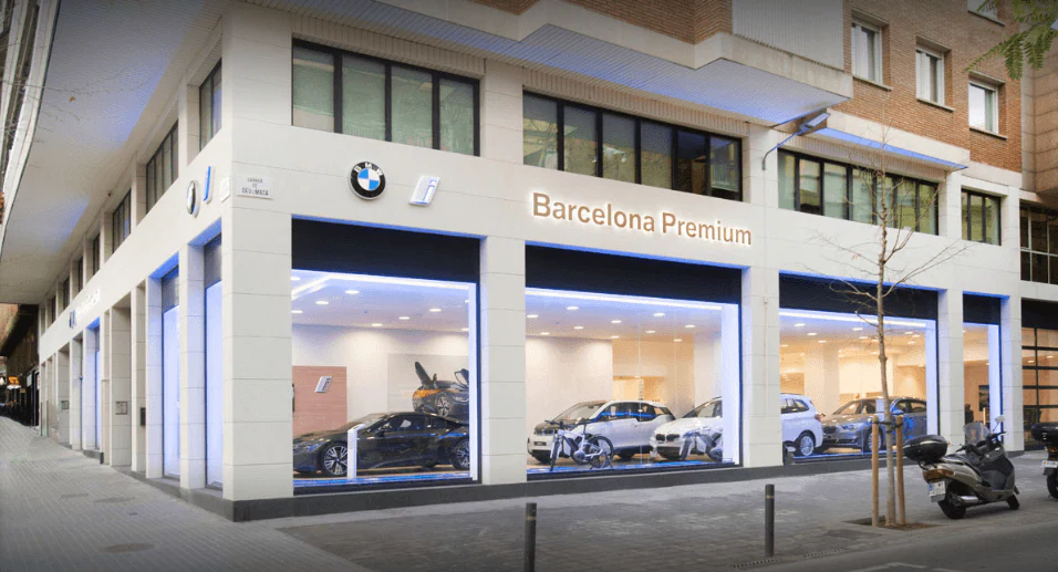 Car dealership façade with lighting over the shop windows