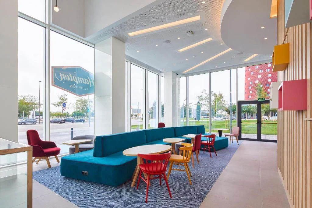 Lobby with colourful sofas and linear ceiling lighting