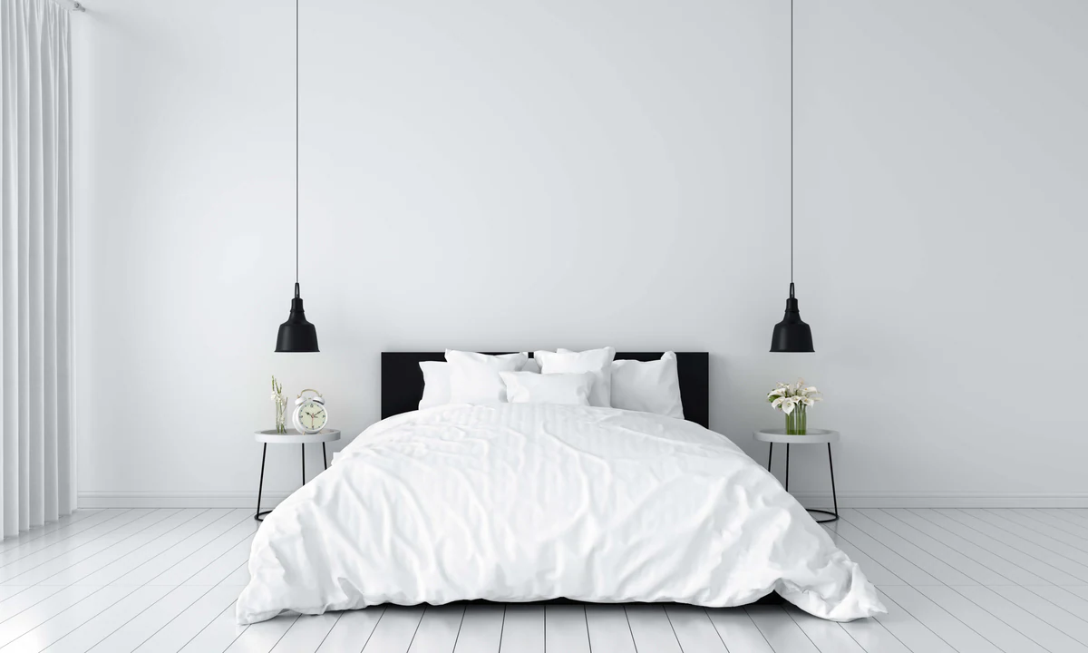 White bedroom with two black lamps beside the bed