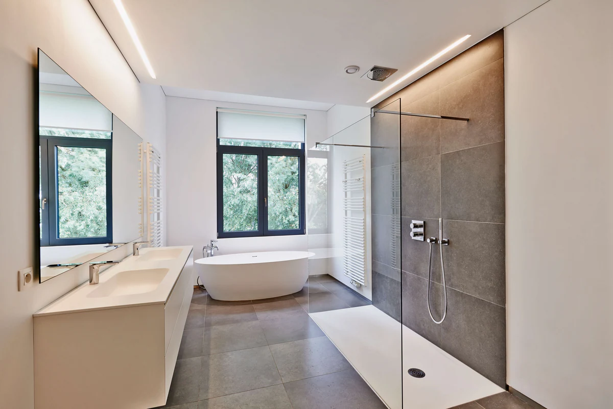 Bathroom with a freestanding bathtub, glass shower and ceiling spotlights