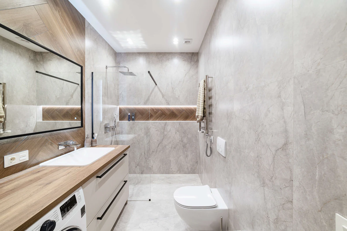 Bathroom with a wooden countertop, large mirror and recessed spotlights
