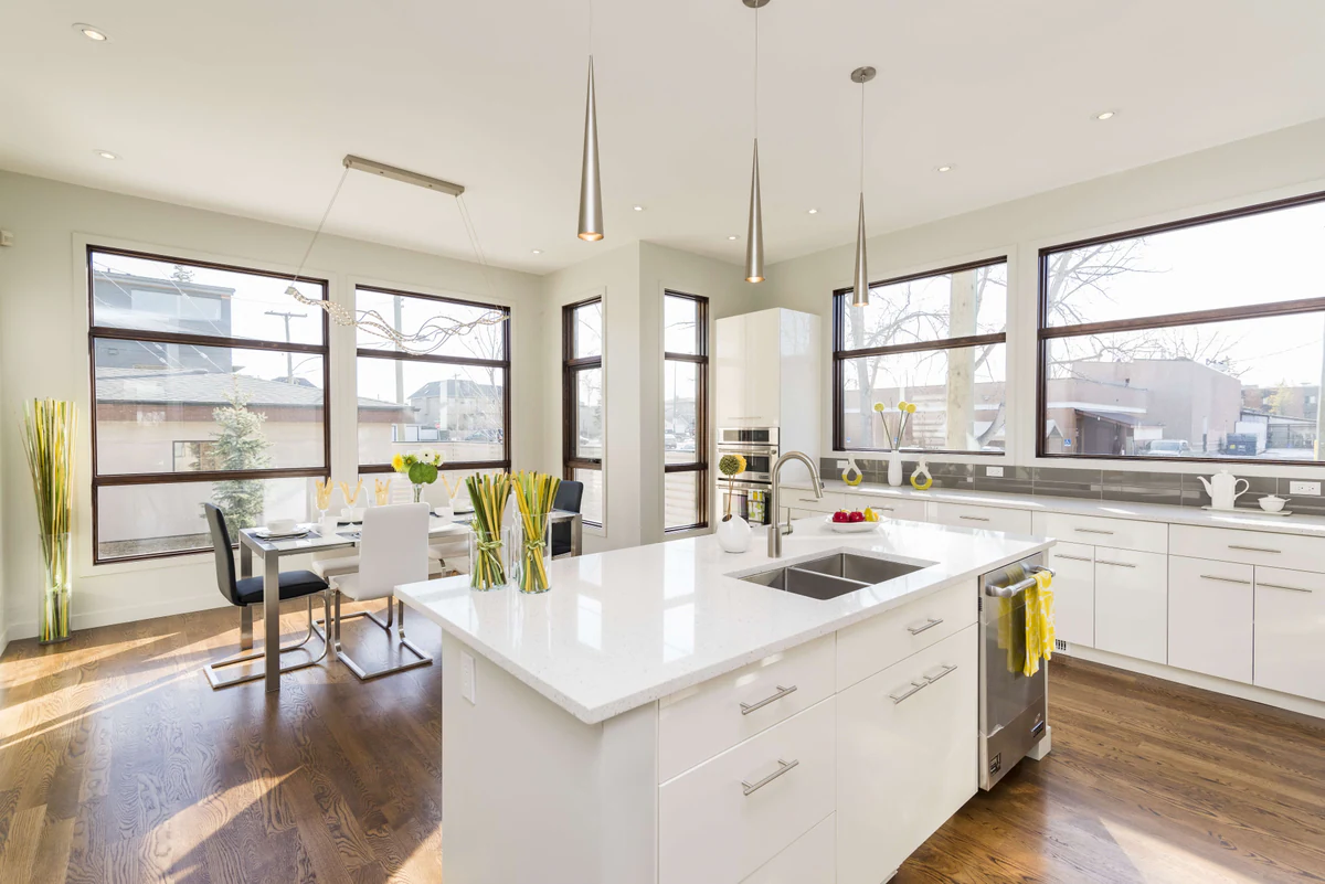 Kitchen with an island, large windows and metal pendant lamps
