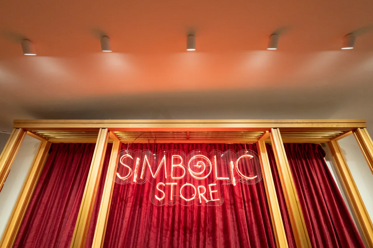 Acceso a la Simbòlic Store de Casa Batlló con iluminación integrada en el techo y cortinas rojas